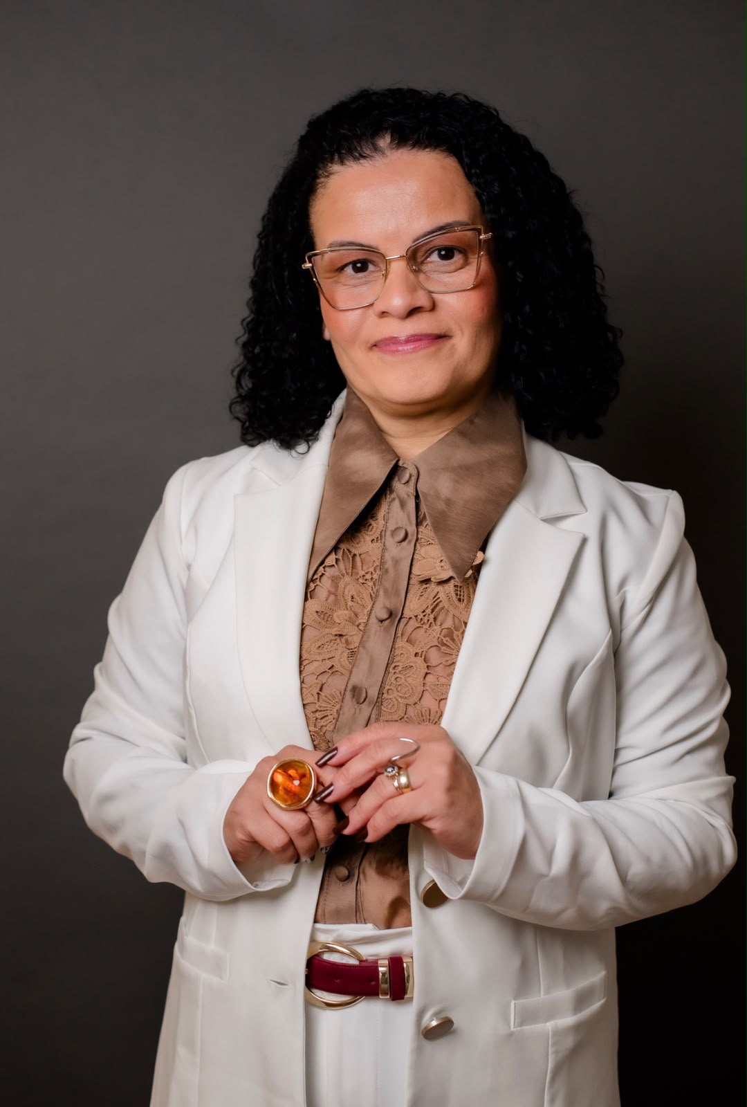 Retrato de Ena Soares em pé, de blazer branco, olhando para a câmera